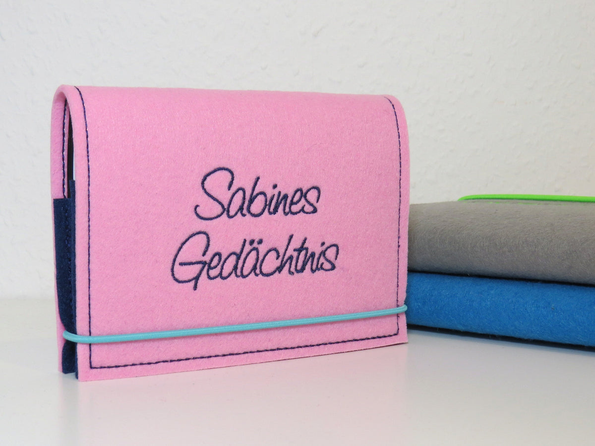 Kalenderhülle A6 aus rosa Filz mit gesticktem Schriftzug „Sabines Gedächtnis“ und Gummiband