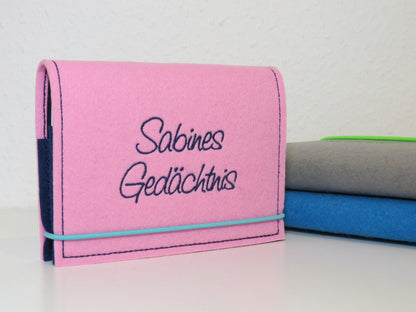 Kalenderhülle A6 aus rosa Filz mit gesticktem Schriftzug „Sabines Gedächtnis“ und Gummiband